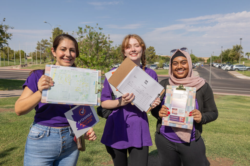 Three yes on 139 Arizona Abortion Access volunteers at Kiwanis Park in Tempe, AZ holding clipboards, ready to canvass