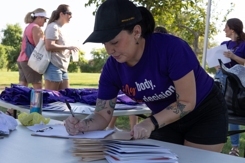 An Arizona Abortion Access volunteer preparing routes for yes on 139 canvassing in Kiwanis Park in Tempe, AZ