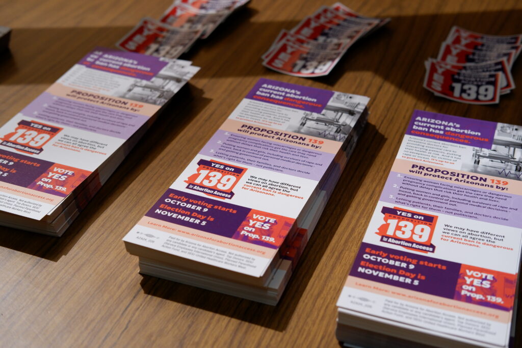 Stacks of yes on prop 139 Arizona Abortion Access canvassing literature and stickers on a wooden table