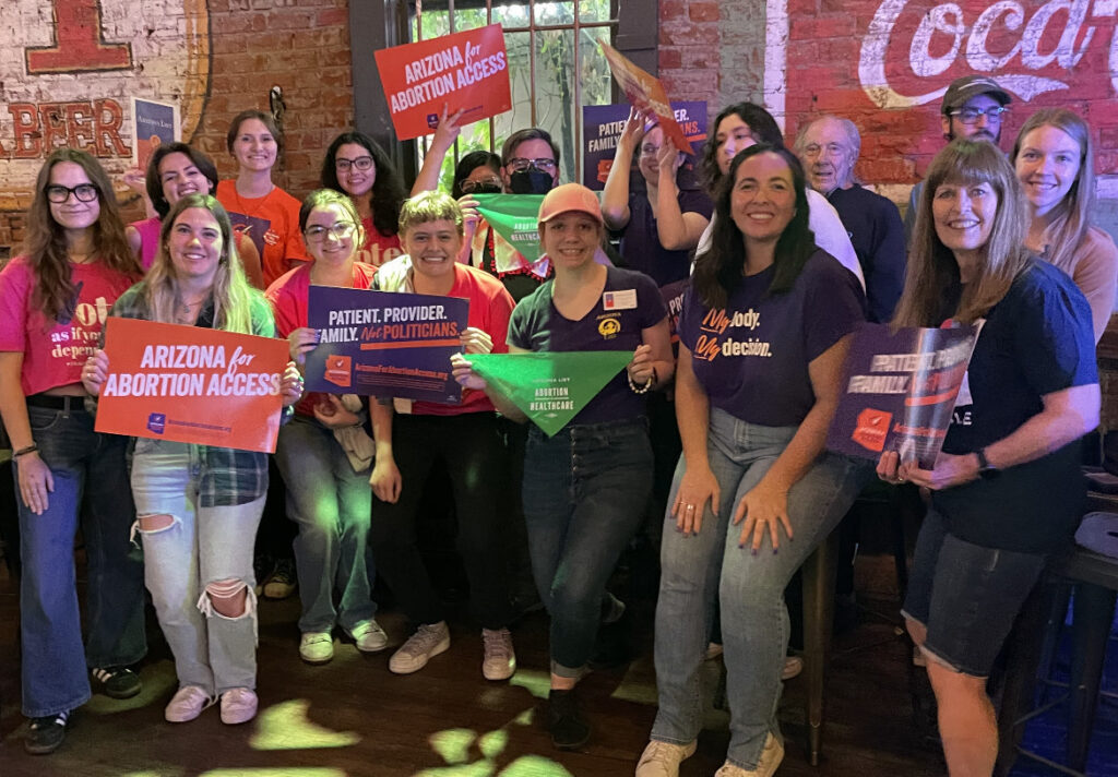 A large group of happy Arizona Abortion Access volunteers in Flagstaff, AZ posing for a photo before canvassing for yes on prop 139